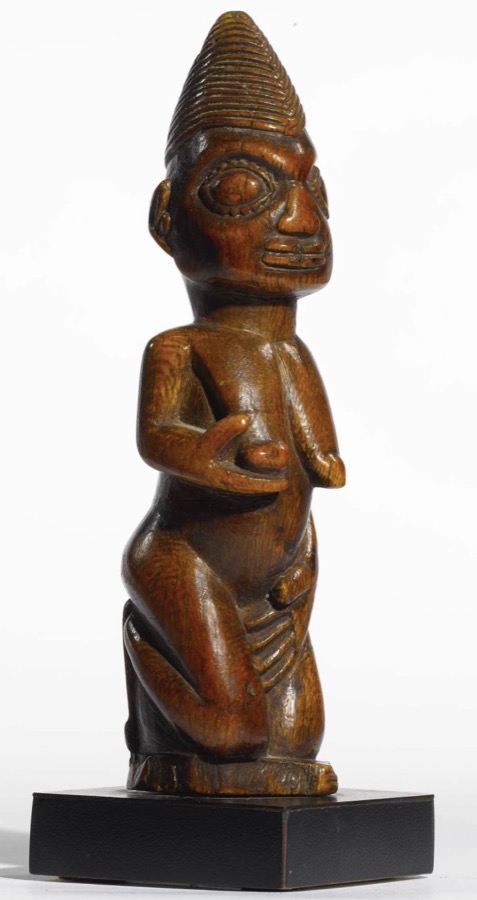 Pair of Yoruba ere ibeji (twin figures) showing characteristic upright posture, elaborate coiffure, and surface patina from ritual care